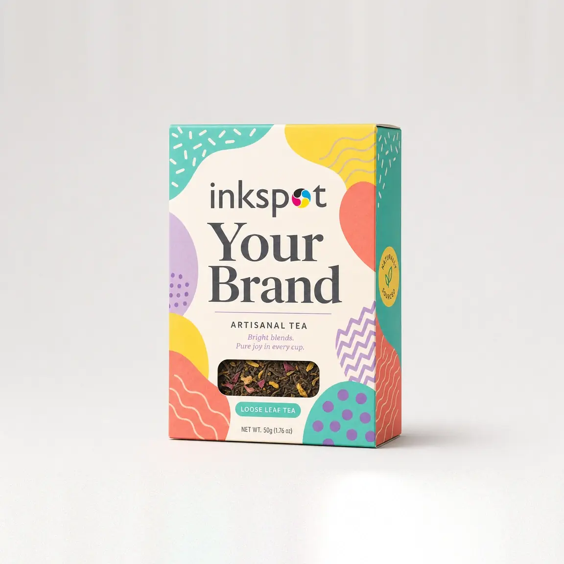 A brightly patterned folding carton of artisanal tea with a die-cut window showing the leaves.