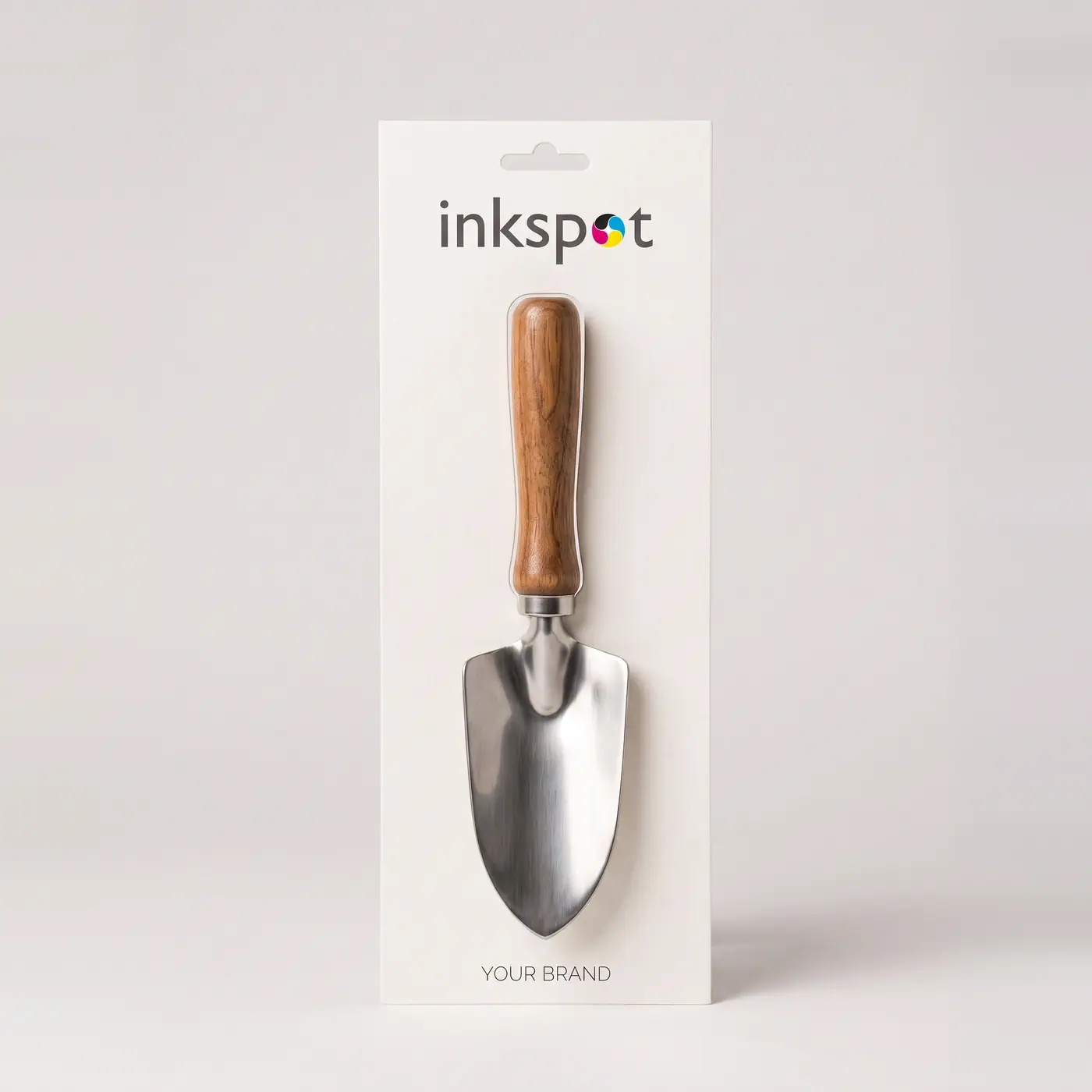 A gardening trowel mounted on a printed backing card with a hang hole.